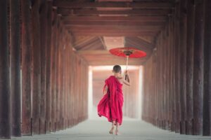 Buddhist Monk Walking alone with umbrella in the street